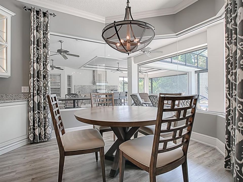 CASUAL DINING SPACE OVERLOOKING THE POOL THROUGH SEAMLESS GLASS SURROUND WINDOW!