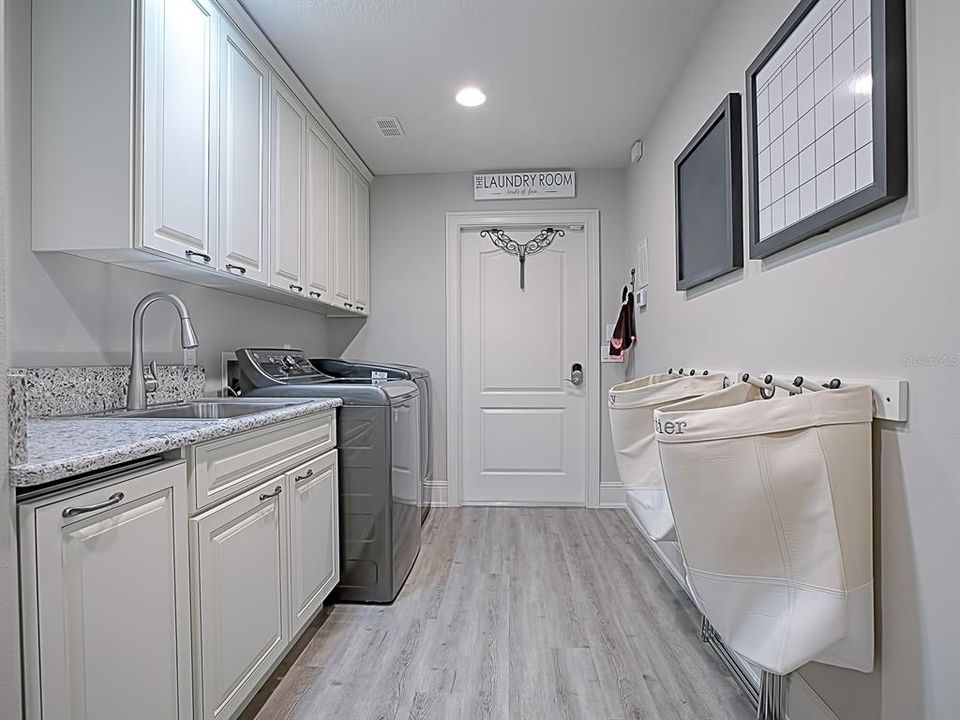 LAUNDRY ROOM WITH SINK AND LOTS OF CABINET SPACE!  WASHER AND DRYER DO CONVEY!