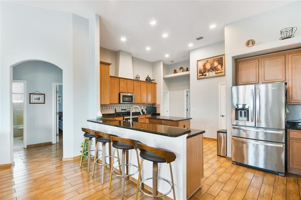 The kitchen is the true heart of this home and boasts STONE COUNTERS, seemingly endless 42” cabinets, a CENTER ISLAND, pantry for ample storage plus DINETTE and BREAKFAST BAR seating for casual dining or entertaining with ease!