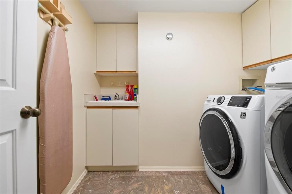 Laundry room with sink and cabinets for storage