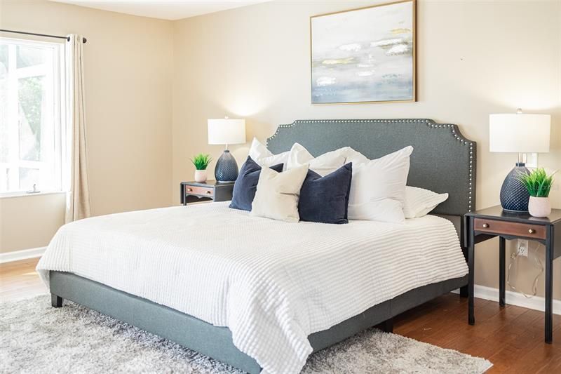 The inviting master bedroom suite overlooks the lake and  has sliding glass doors with a picturesque view of the lake and access to the screened  lanai and pool patio.