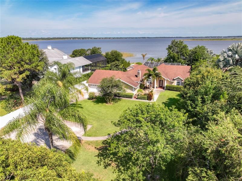 Aerial view of the home with the lake in the back ground.  There is plenty of driveway and parking areas for your boat, trucks, trailers and boy-toys.