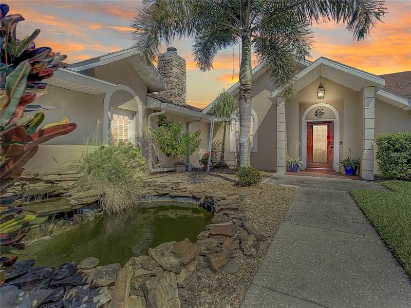 CUSTOM BUILT LAKEFRONT POOL HOME with 5 BR / 4 BA and 100’ OF LAKEFRONTAGE on LAKE HAMILTON.  Koi pond is to the left of the side walk.