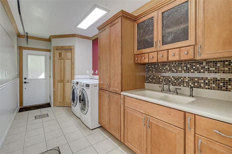 Inside laundry has built in cabinets and a wash sink.