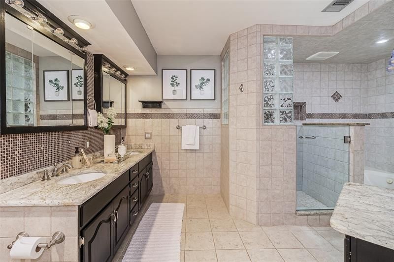 This en-suite luxury bathroom has a large vanity with double sinks, walk-in shower and a  jetted bathtub