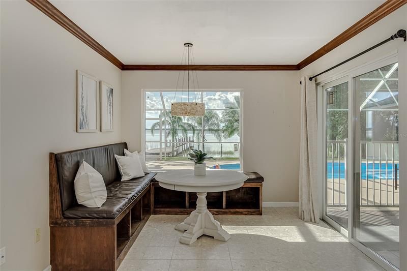 Dinette area has built in seating with an amazing view of the pool and lakefront area thru the picture window.  Double sliding glass doors open to the lanai and the screened pool cage.