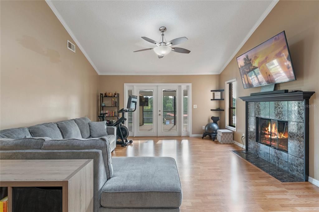 This awesome floor plan is bright and open and offers a living space with a VAULTED CEILING with a WOOD BEAM, cozy FIREPLACE with a tile surround, WOOD LAMINATE FLOORS and FRENCH DOOR ACCESS to the Florida Room!