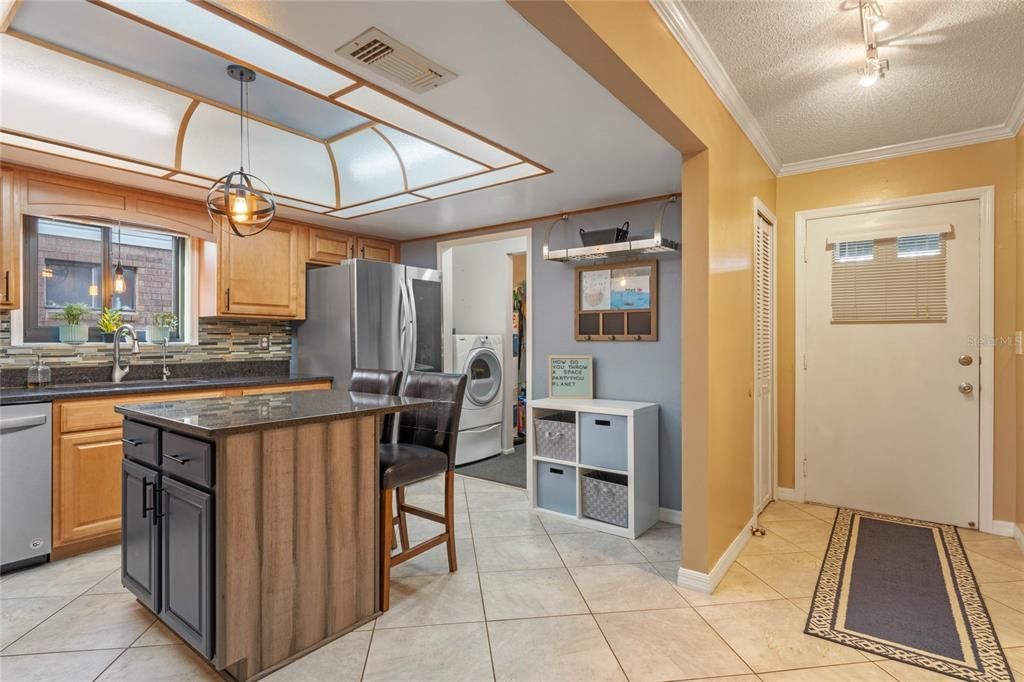 The kitchen has been thoughtfully UPDATED and boasts custom cabinetry with a mix of drawers and cabinets, GRANITE COUNTERTOPS, glass tile backsplash, STAINLESS APPLIANCES, and a good size CENTER ISLAND with BREAKFAST BAR seating!