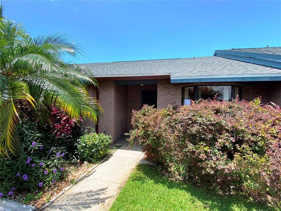 Lushly landscaped front exterior with BRAND NEW ROOF