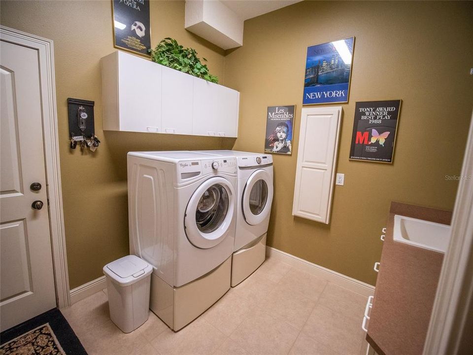 Laundry room with cabinetry, sink, and stowaway in-wall ironing board