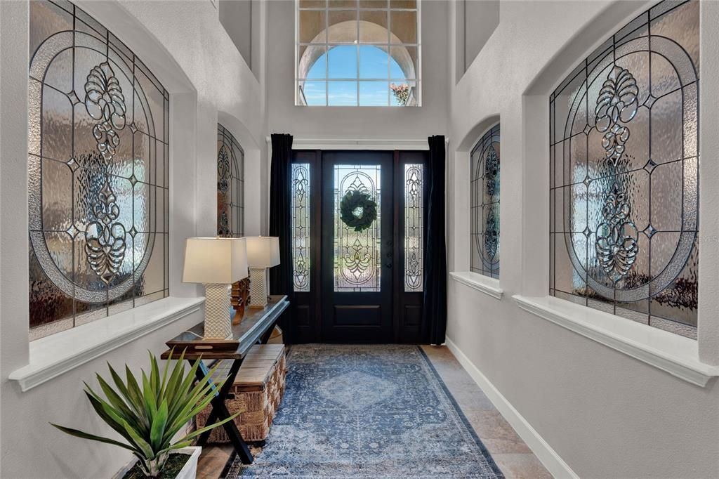 Massive front door leading you to a stainglass wall corridor