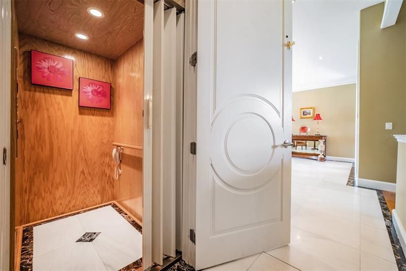 Interior elevator with marble floors and wood accent walls