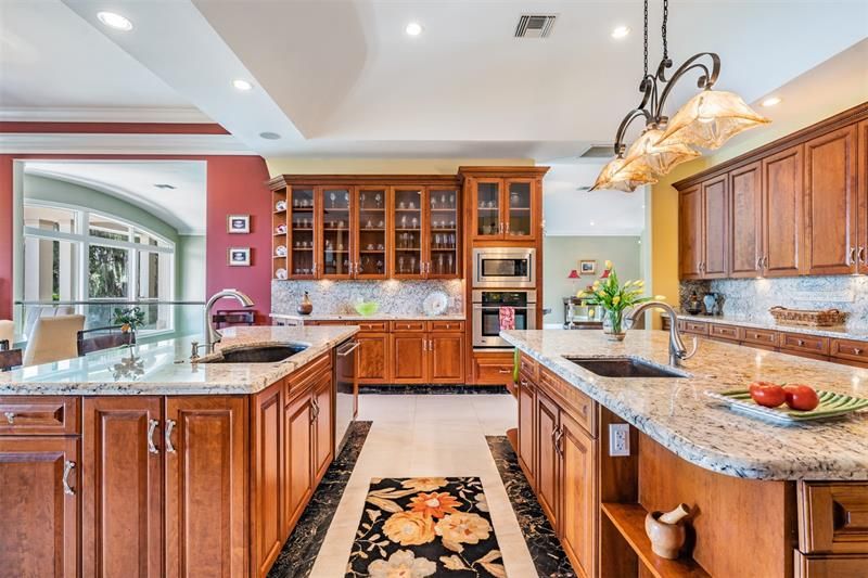 Warm wood cabinets with gleaming granite counters and backsplash