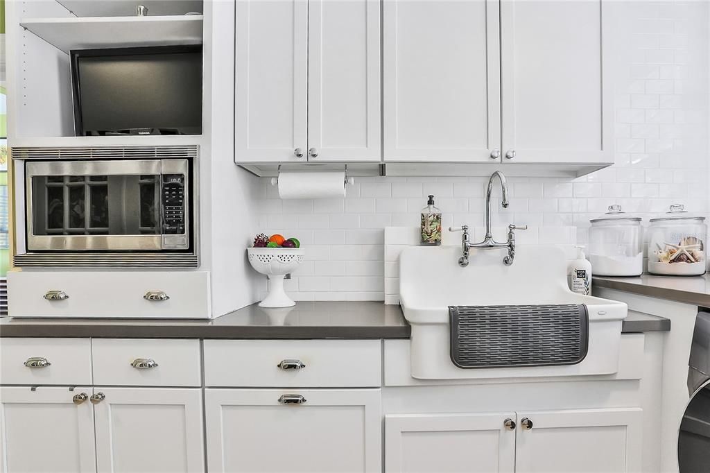 Laundry room with an extra sink and microwave for your convenience.