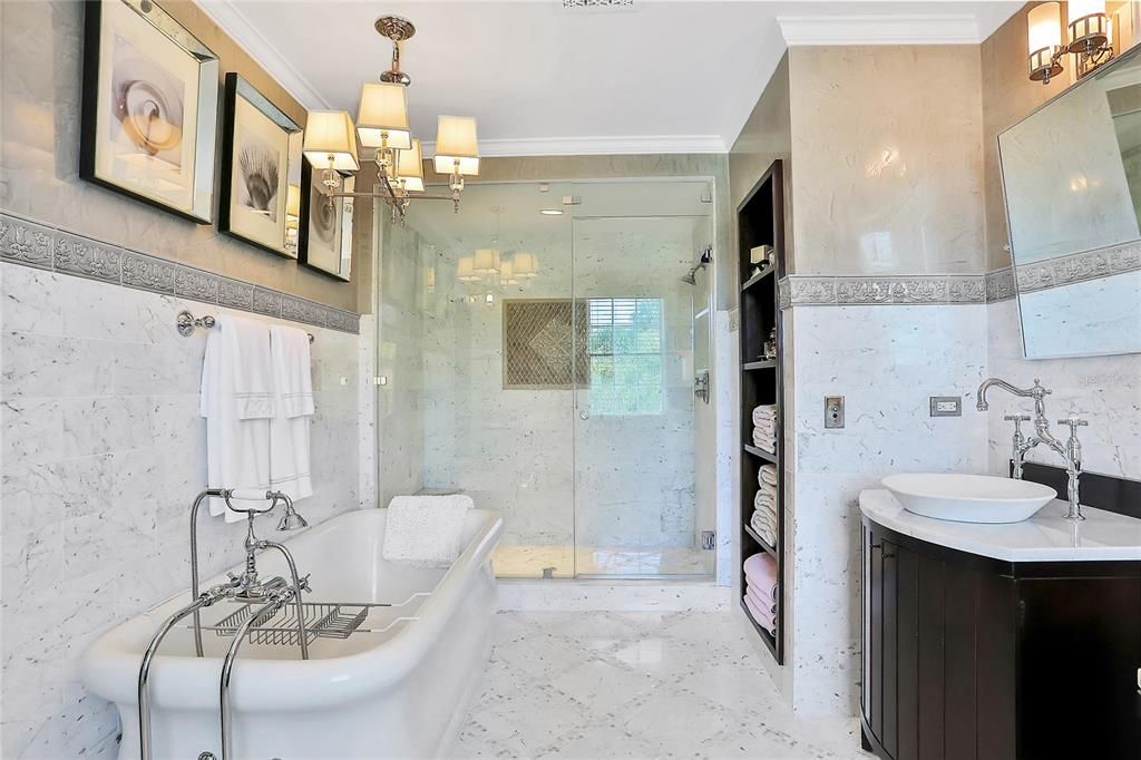 Her master bathroom with separate shower and tub overlooks the pool and lush backyard.