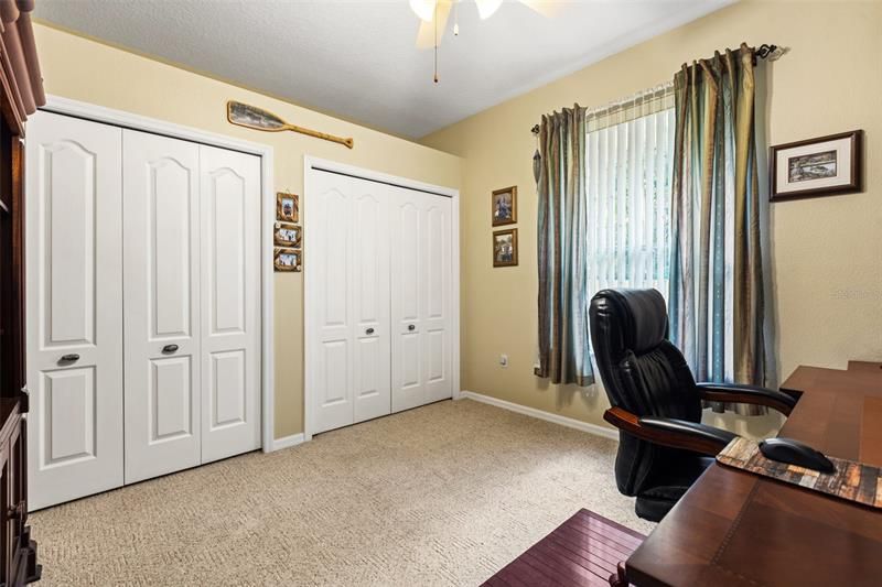 Bedroom with wall to wall closet and large windows