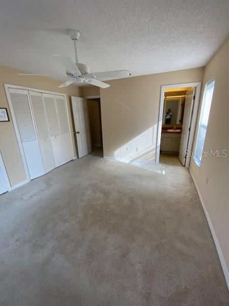 Primary Bedroom with bathroom and wall of closets