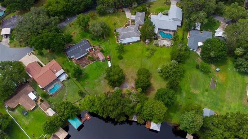 arial view of home, back yard, and canal access, with dock