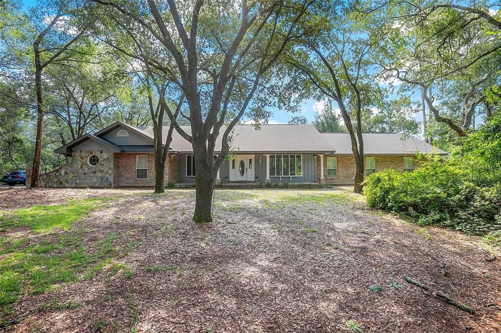 FRONT EXTERIOR WITH SURROUNDING LIVE OAKS