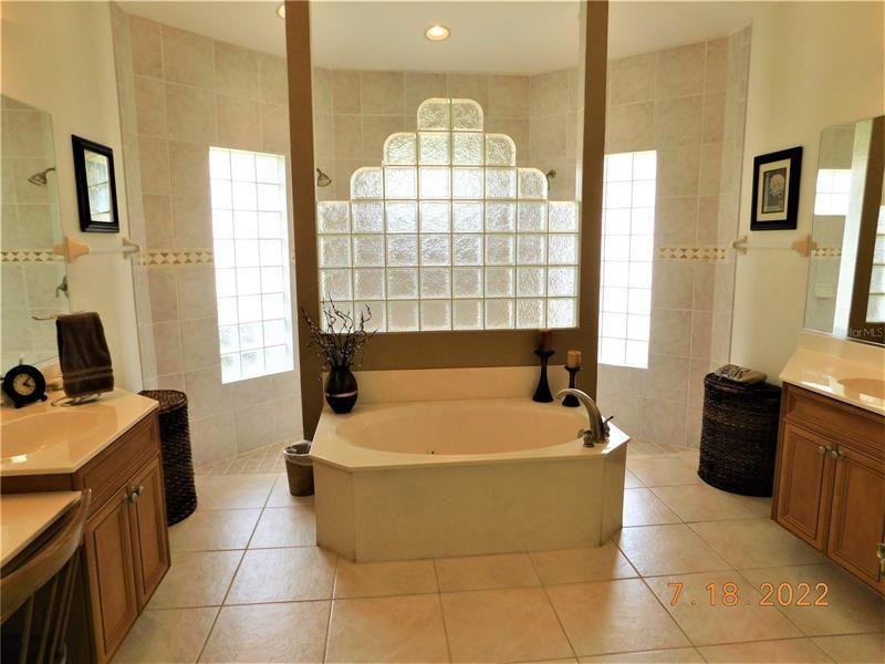 Walk-around shower and jetted tub with separate vanity areas