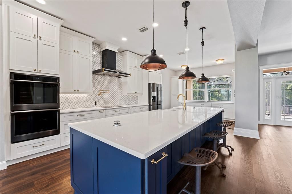 Custom Kitchen with oversized center island with pop up plugs