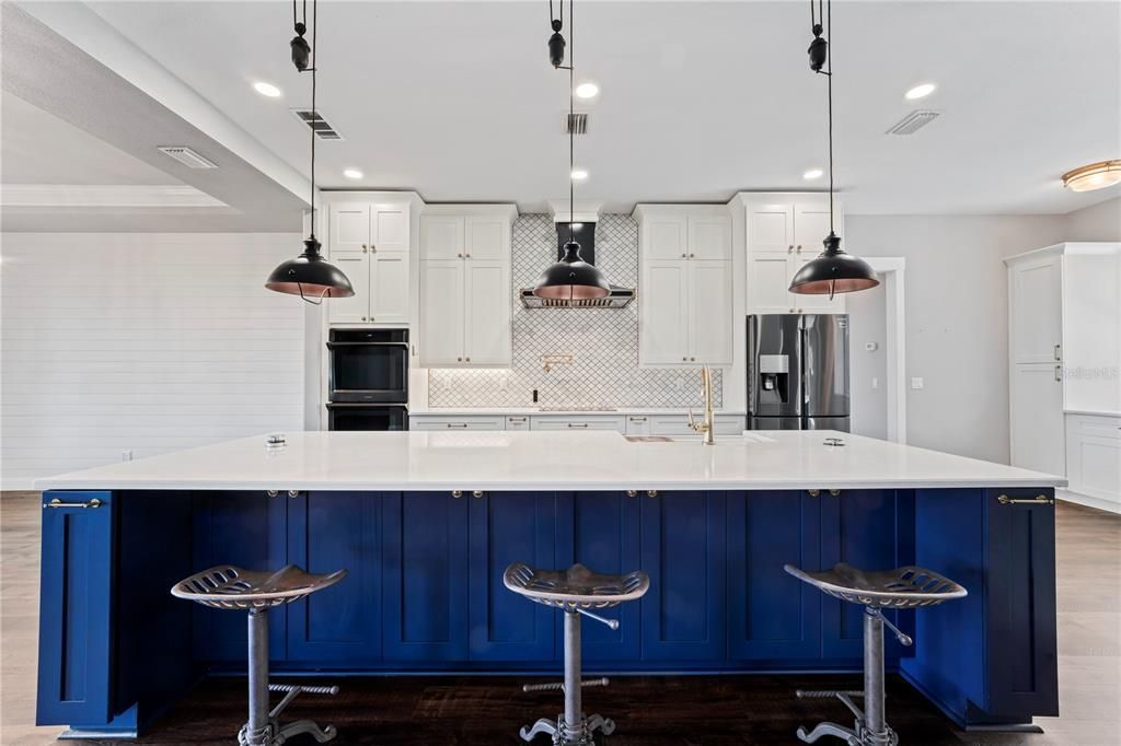 Custom Kitchen with oversized center island with pop up plugs