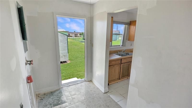 Laundry Room with Kitchen to the Left and Storage Shed in Backyard thru Door!