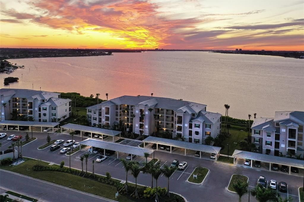 Twilight Aerial View of Building 2 in Tidewater Preserve the Shores. Built in August of 2019 this is a ground floor unit with no Carpet. Come see this condo with sunsets year round.