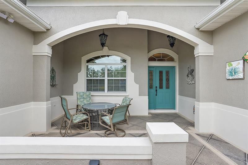 Covered front entrance with elegant leaded glass door