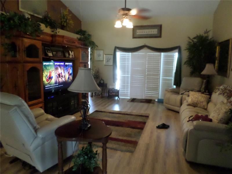 LIVING ROOM VAULTED WITH DECORATIVE SHELF (PLATATION SHUTTERS THROUGHOUT HOME )OPENS TO LANAI