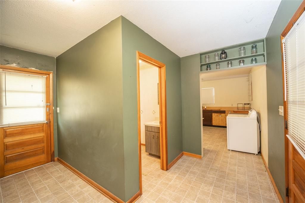 Interior back entrance with access to laundry room and half bath