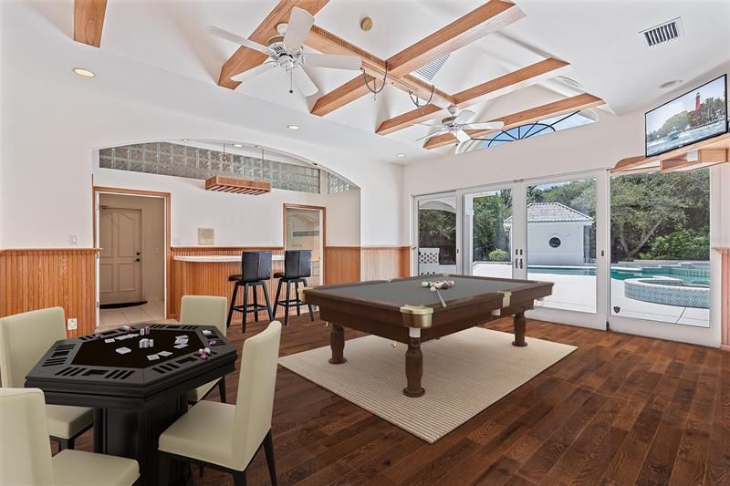 virtually staged club room with wet bar and pool views.