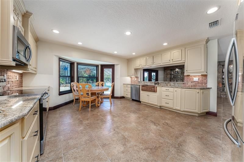 Kitchen features new granite counter, new copper farm house sink, new brick backsplash, S/S  and new windows and new French door to access the backyard &pool.