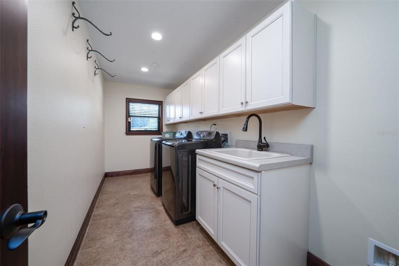 Large interior laundry room with all new cabinets and sink. Space to the right of sink is perfect spot of extra refrigerator or more storage.