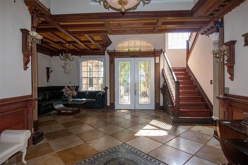 View from formal dining towards front entry. Coffered ceilings. Carved wood, diagonal flooring.