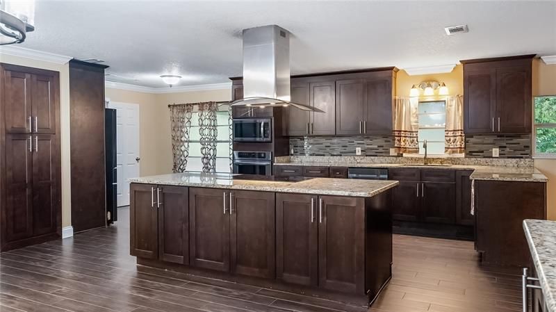 Updated kitchen with granite counters, cook top island with new stainless exhaust hood