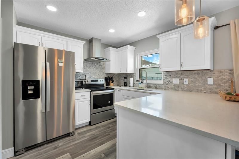 Your eye will immediately be drawn to the REMODELED KITCHEN boasting beautiful cabinets with CROWN MOLDING, STONE COUNTERS, custom TILE BACKSPLASH, STAINLESS STEEL APPLIANCES and a BREAKFAST BAR for casual dining or entertaining!
