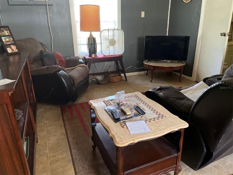 Living room with tile floors and window unit air conditioner