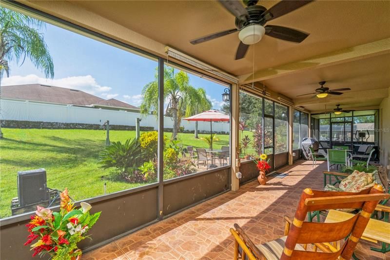 Large Paved  screened in covered lanai the whole lengh of the back of the home plus and outdoor patio area overlooking a large backyard.