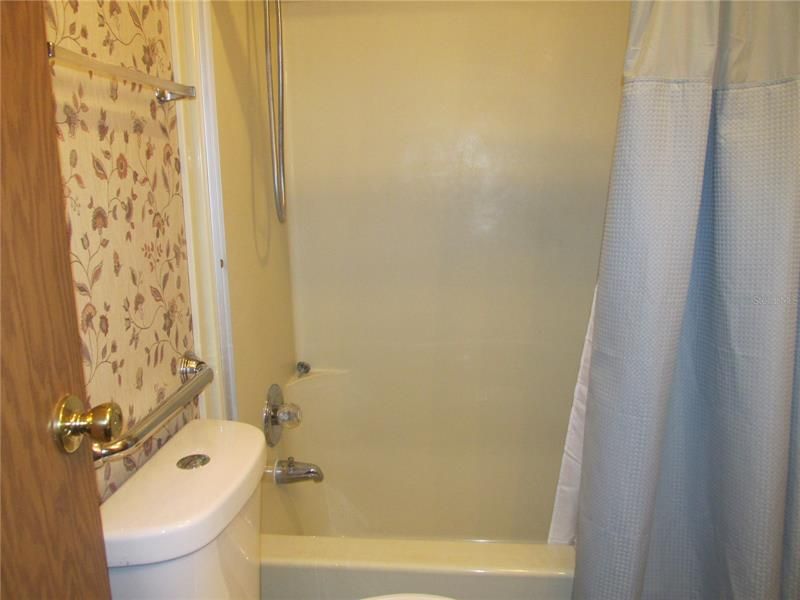 The bathroom has a tub and shower, and a water saving toilet.