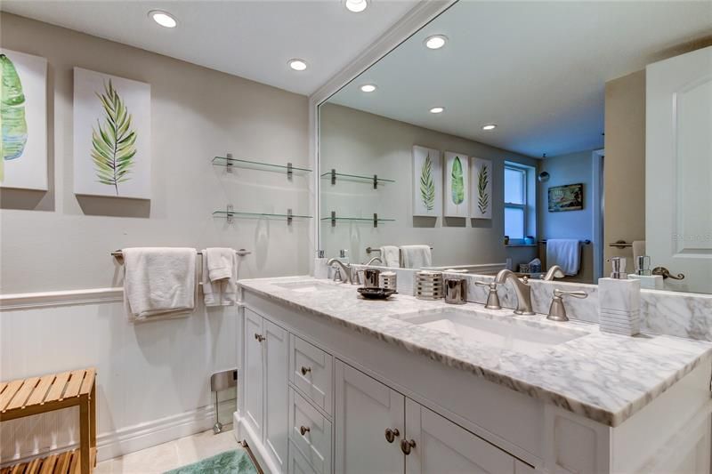 Bathroom #2 Features a dual sink vanity with marble top, bead board walls, recessed lights