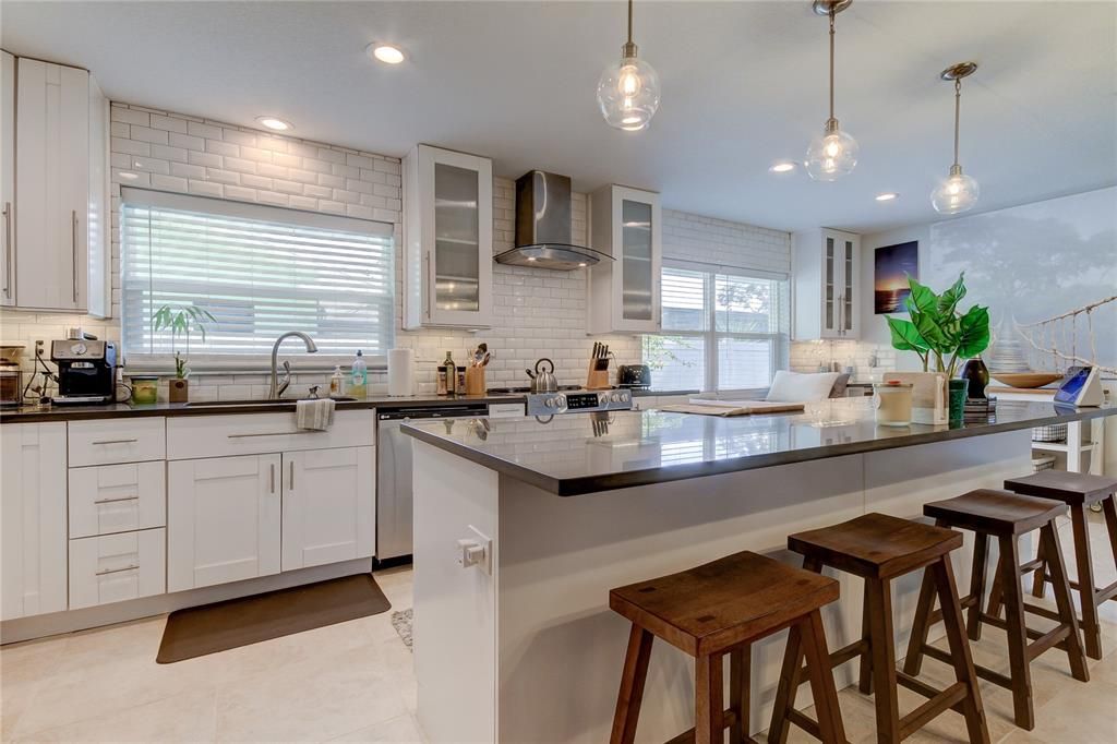 12' breakfast bar is adorned with 3 moody pendant lights on dimmers