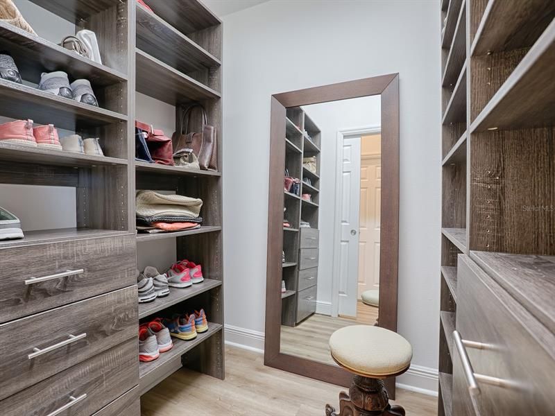 ONE OF THE MASTER BEDROOM CLOSETS WITH BUILT-IN SHELVES AND DRAWERS.