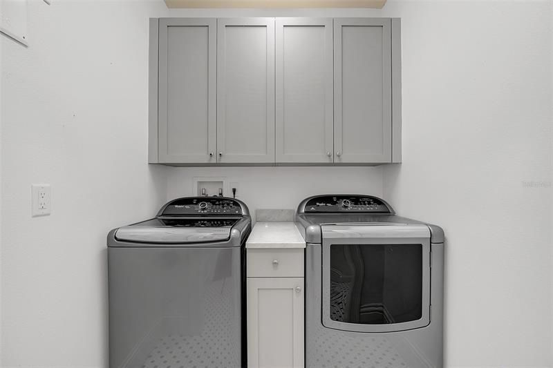Laundry Room next to mud room area with built-in shelving and cabinets