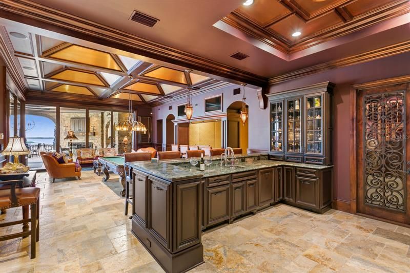 This is a stunning well thought out Family Entertainment Room and Theater!  As you walk into the room you will see the bar with an ice maker and sink.  The door to the right is the entrance to a 1,500 bottle wine room