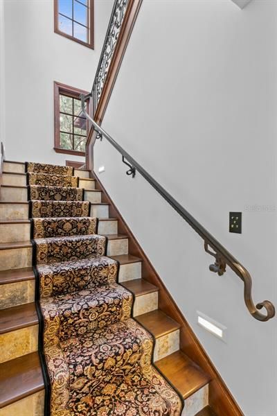 The stairs leading to the second floor have gorgeous marble risers and a luxurious rug runner