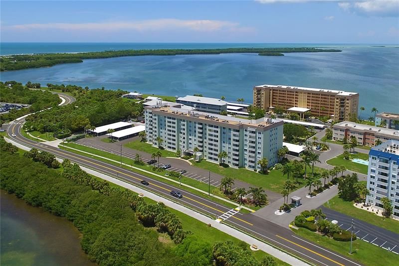 The fabulous Forbes building  in the center of the photograph.  As you enter Royal Stewart Arms, take the second entrance, the Forbes Building will be  on your left, with the island dolphin pool in front of you, as you proceed to your own private carport.  Royal Stewart arms is one of two only communities that has ever been built on the tropical island Honeymoon Island.