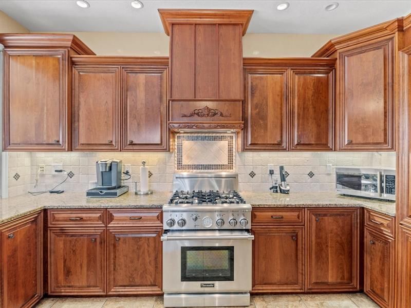 Close Up View of the 4 Burner Gas Top Range w/ Electric Oven for Perfect Cooking/Baking and the Custom-Made Matching Cherry Wood Range Vent Hood