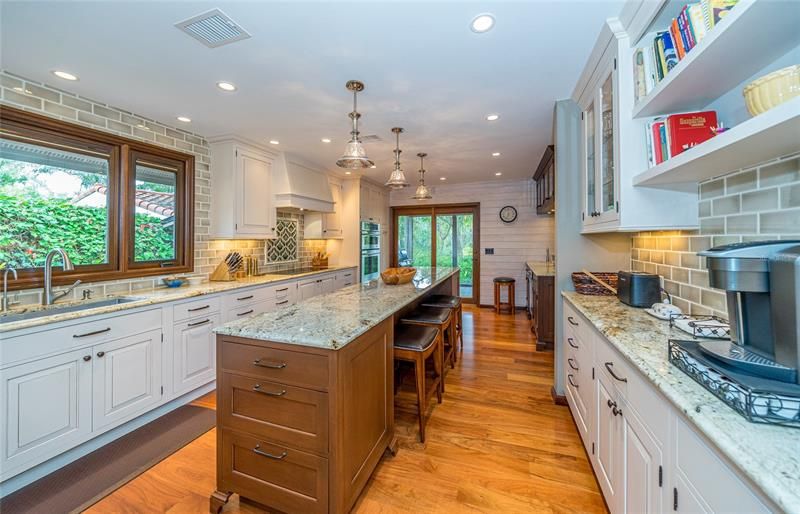 Luxury kitchen with custom, inset wood cabinets and exotic granite