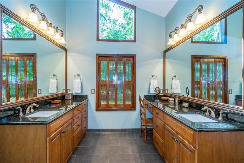 Master bath with separate custom maple vanities, granite countertops, porcelain tile floor
